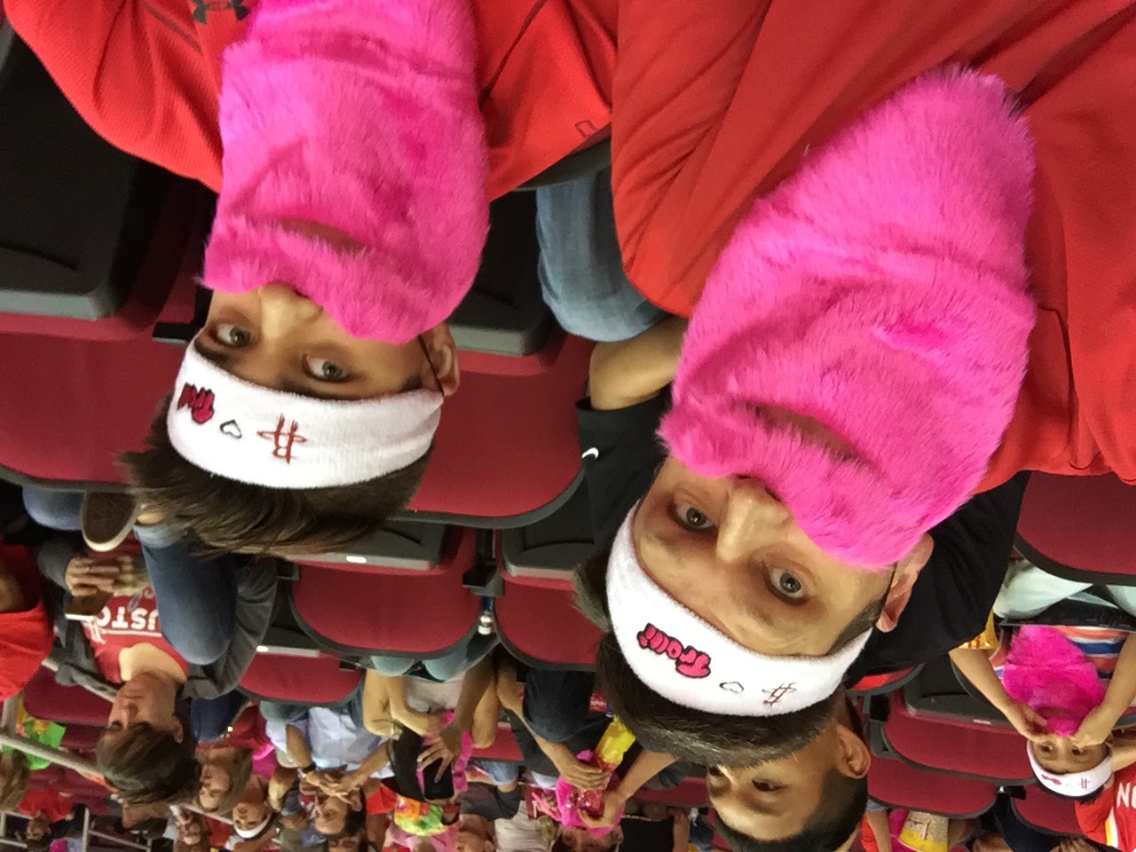 Braden and his father wearing pink Rockets playoff beards at a basketball game